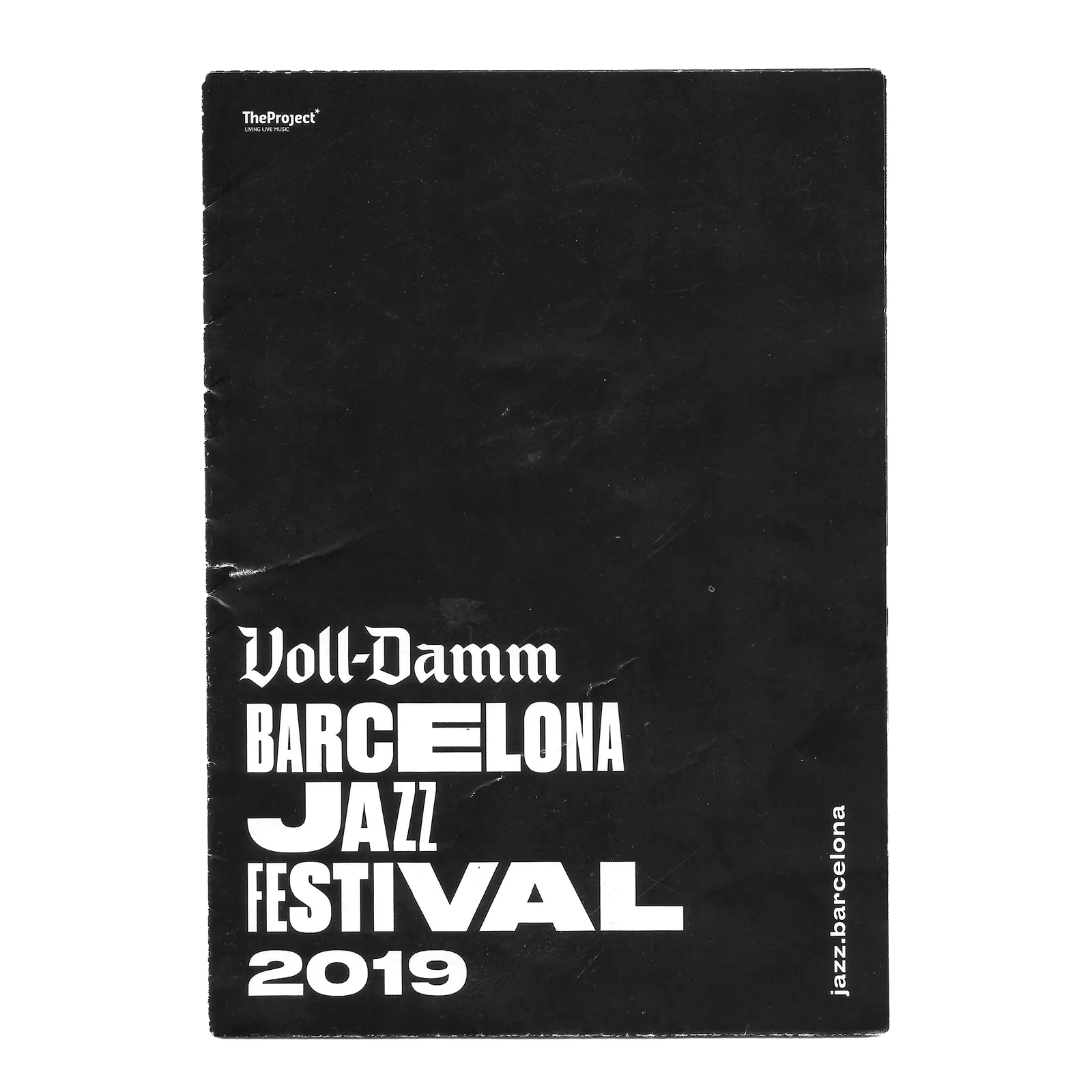 Scan of a black bag from the 2019 Voll-Damm Barcelona Jazz Festival, the paper creased and the edges frayed