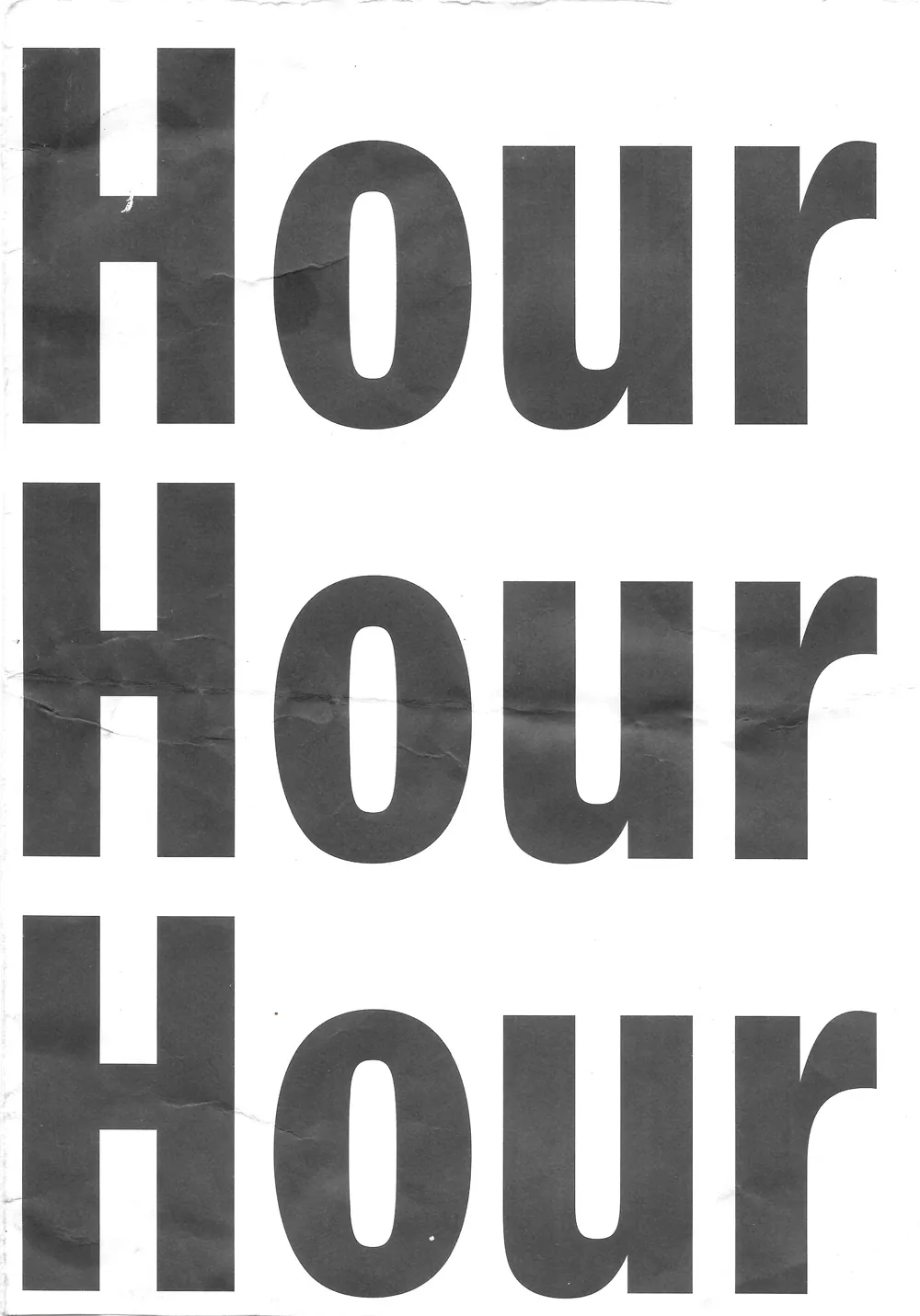 Scan of a creased sheet printed with the word «Hour» three times, one line under the next, in heavy grotesque type set large enough to run off both edges of the page